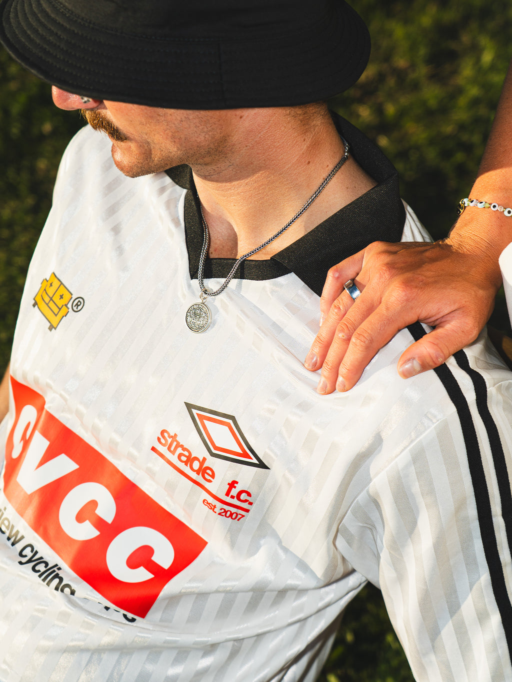 Person wearing a sports jersey with visible couch view branding, sitting outdoors.