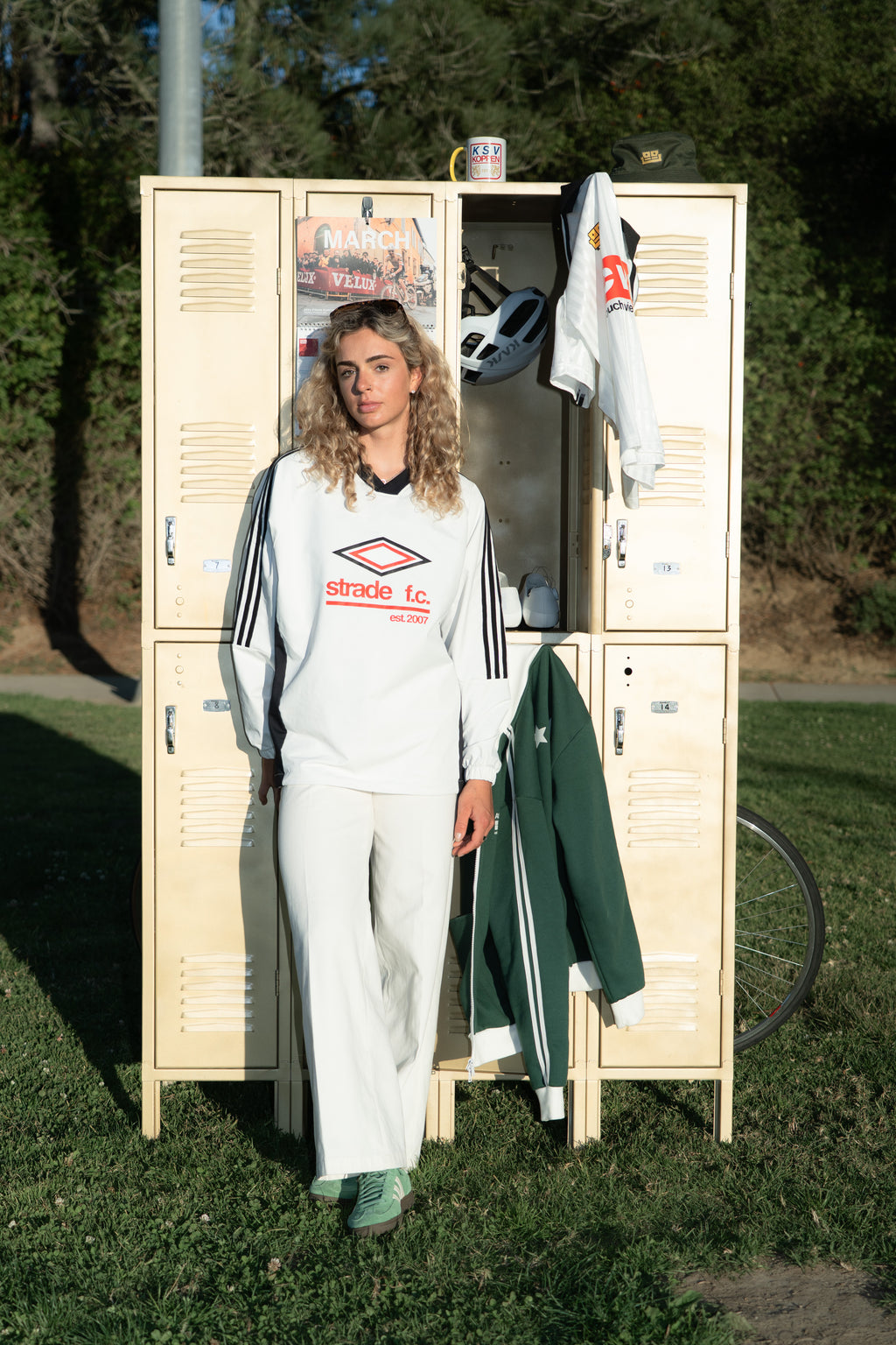 Person wearing couch view long sleeve shirt standing next to a locker with various items inside, outdoors.